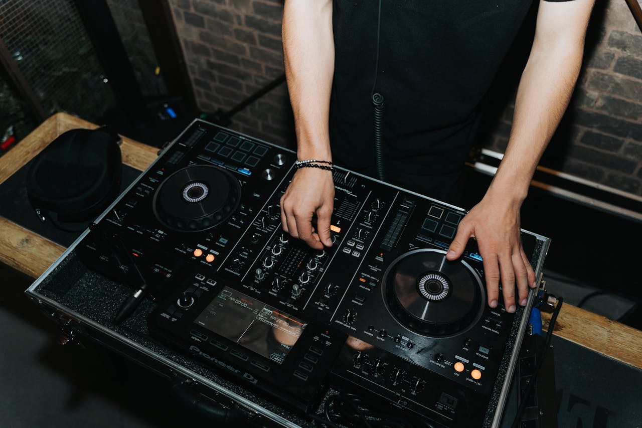 Close-up of a DJ using a mixer in a nightclub setting in Curitiba, Brazil.